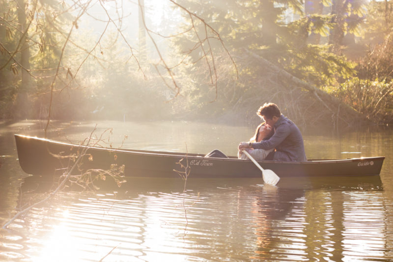 couple kissing on lake in canoe